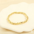 Close-up of golden beaded bracelet with faceted beads on a ceramic scallop plate - BR1683-I/Gold Diamond-cut Craft Beads