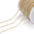 Golden bead chain with small champagne crystal beads on a white spool for jewelry making - Clear White/3mm/04