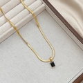 Elegant gold snake chain necklace with black rectangular gemstone pendant on display stand - Gold Black Zirconia