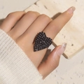 Detailed view of a large black heart-shaped ring with pavé crystals on a model's finger - Adjustable Open / Black Heart Style (6073BK)