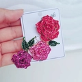 Dettaglio ravvicinato di una lussuosa spilla a tre rose con strass di cristallo scintillanti - Colorato