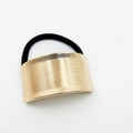 Close-up of golden hair cuff detail with brushed metal texture and black elastic band - Horizontal Brushed Texture (Hair Tie 28)