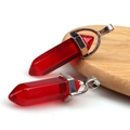 Two red hexagonal crystal pendants with silver bail on a natural wood base - Transparent Red