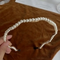 Close-up of elegant wavy pearl headband with white pearls on a gold metal base - Gold Wave Pearl