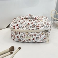 Gros plan détaillé d'une trousse à maquillage matelassée blanche avec motifs chat et pomme - Ange Chat