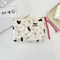 Close-up of quilted floral pouch with cute animal prints and a pink zipper pull cord - Black Cat & Dog