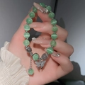 Dettaglio del bracciale occhio di gatto verde con ciondolo a farfalla in cristallo e nappa - Verde Argentato (17# Bracciale-Verde Argentato)