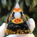 Orgone crystal pyramid with orange chakra symbol and black obsidian base held in hand - White Ball Ego / Small