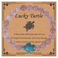 Pink natural stone beaded bracelet with blue sea turtle charm on greeting card - Strawberry Quartz