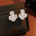 Detalle macro de pendientes de flor plateados con circonitas y perla blanca colgante - Plateado