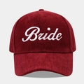 Detail view of white embroidered Bride text on a burgundy corduroy baseball cap texture - Adjustable / Bride Wine Red