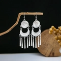 Close-up of vintage silver long tassel earrings with intricate ethnic engravings - Retro Carved Disc Long Tassel Style (E4458)