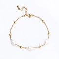 Dettaglio macro del bracciale dorato impermeabile con tre eleganti perle ovali bianche - Accento con Tre Perle / Oro