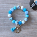 Macro shot of light blue and white silicone beads keychain with leather tassel on wood - Sky Blue