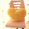 Yellow heart shaped plush pillow in soft fabric placed on a modern pink chair - Yellow Heart