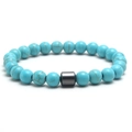 Elastic beaded bracelet with turquoise stones and a cylindrical metallic bead on white back - Turquoise
