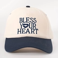 Close-up of 'BLESS YOUR HEART' embroidery on a beige and navy blue baseball cap - Cream/Navy Blue