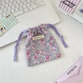 Detail of floral fabric drawstring pouch featuring purple patterns and Sorakka brand label - Full Floral