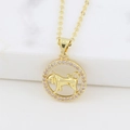 Close-up of gold zodiac Taurus pendant with pink crystal on white marble - Taurus