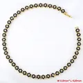 Detail view of flower necklace featuring black enamel petals and crystal centers, 8mm width - Gold Black Zirconia Necklace (VL526)