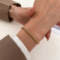 Minimalist gold snake chain bracelet for women shown worn on a wrist with an elegant suit - 18K Gold Snake Chain (K-771)