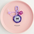 Detailed view of a purple poker chip and dice keychain set on a pink tray display - Transparent Purple Dice with Hand Strap / Purple-500 Value