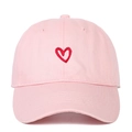 Pink cotton baseball cap with red embroidered heart design on a plain white background - Red Heart Embroidery / Pink
