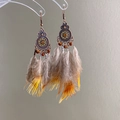 Detail of vintage ethnic bronze earrings featuring mandala discs and amber beads with feathers - Style 4 Mandala Feather - Gray