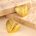 Detail of golden heart earrings with textured stripes on travertine stone display - Style 7-Textured Pleated Heart Studs