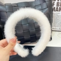 Close-up of fluffy white faux fur headband featuring soft plush texture on black bag - High Quality White