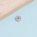 Nahaufnahme einer polierten silbernen Edelstahlscheibe als Zwischenperle mit Mittelloch - 6mm / Stahlfarbe