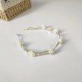 Detalle de diadema ondulada dorada con rosas beige y pequeñas cuentas de perlas - Blanco