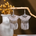 Detail of silver fan-shaped boho tassel earrings hanging on a natural wooden branch - Silver Fan Feather Tassel(E2875-27)