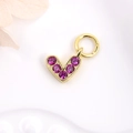 Close-up of golden heart pendant with magenta zircon for DIY jewelry making - Fuschia