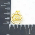 Golden evil eye zircon charm pendant on a measuring ruler showing product dimensions - Evil Eye