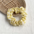 Yellow floral print fabric scrunchie on a woven basket for hair styling - White with Yellow Floral