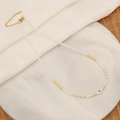 Macro detail of evil eye necklace with white crystal beads and gold heart shell pendant - Oval Shape