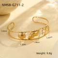 Detailed view of ocean theme gold bangle featuring starfish shell and pearl charms - Marine Element Pearl Double Layer Bangle