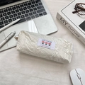 Detail of white wrinkled fabric pencil case with tulip embroidery on office desk - White