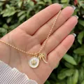 Detalle de cadena de bolas en oro de 18K con colgantes de concha y palmera de playa - Palmera y Concha