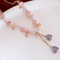 Detalle de pendiente de cuentas de cristal rosa con flores y borlas moradas colgantes - Collar de Cuentas Rosa Hecho a Mano