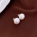 Macro detail of round white pearl stud earrings with golden needles on textured fabric - Gold Needle White Pearl Studs (14mm)