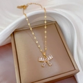 Luxury gold butterfly pendant necklace with cubic zirconia on a white silk background - Gold Bowknot Style (F218)