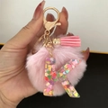 Detail of pink resin letter K keychain with heart glitter, pompom and tassel charm - Letter K