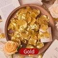 Metallic gold artificial rose petals for wedding decor displayed in a wooden tray - Gold