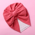 Detailed view of the double-layered bow and elastic knit fabric on a baby turban hat - Watermelon red