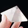 Hand holding a transparent natural white crystal pyramid for energy and home decor - 9.5CM