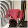 Dettaglio borsa fucsia asimmetrica con catena, hardware argento e finitura in ecopelle - rosa acceso