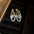 Elegant gold earrings featuring white pearls and sparkling zircons on a velvet display - Gold Double Layer
