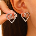 Macro view of silver twisted hollow heart earrings with vintage textured pattern - Silver Twist (N-034)